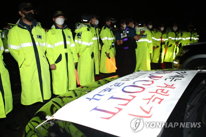 자영업자들이 지난달 25일 오후 부산 사상구 삼락생태공원 주차장에서 차량 시위 시작에 앞서 경찰과 대치하고 있다. 연합뉴스