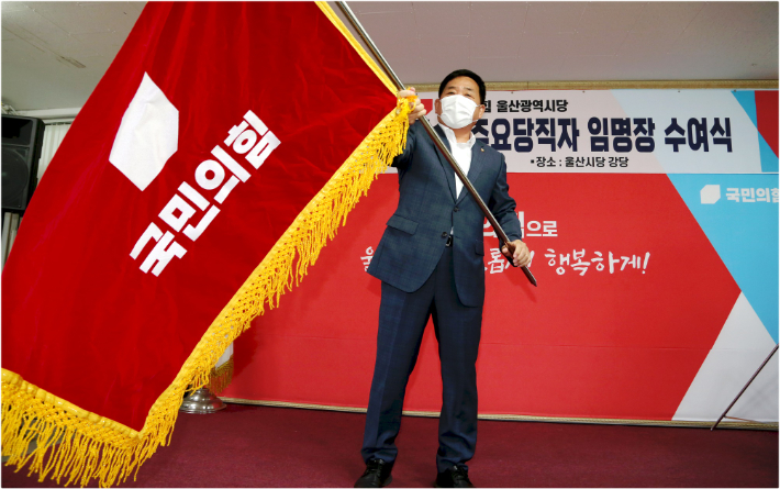 박성민 신임 시당위원장은 6일 전임 시당위원장인 이채익 국회의원에게서 전달 받은 당기를 흔들고 있다. 국민의힘 울산시당 제공
