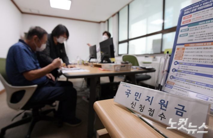 1인당 25만 원 규모의 코로나 국민지원금 신청 접수가 시작된 지난 6일 서울 양천구 목1동 주민센터에서 어르신들이 안내를 받는 모습. 이한형 기자