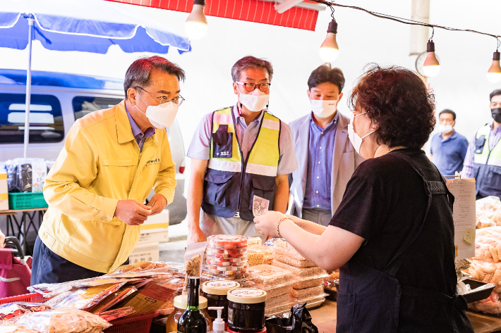지난해 추석에 장보기를 하며 시장 상인과 담소를 나누고 있는 김선갑 구청장(사진 왼쪽). 광진구 제공 