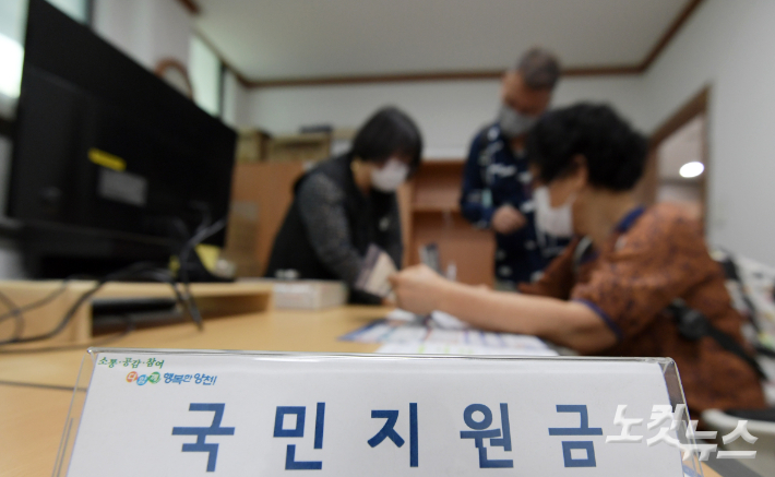 1인당 25만 원 규모의 코로나 국민지원금 신청 접수가 시작된 지난 6일 서울 양천구 목1동 주민센터에서 어르신들이 안내를 받고 있다. 이한형 기자