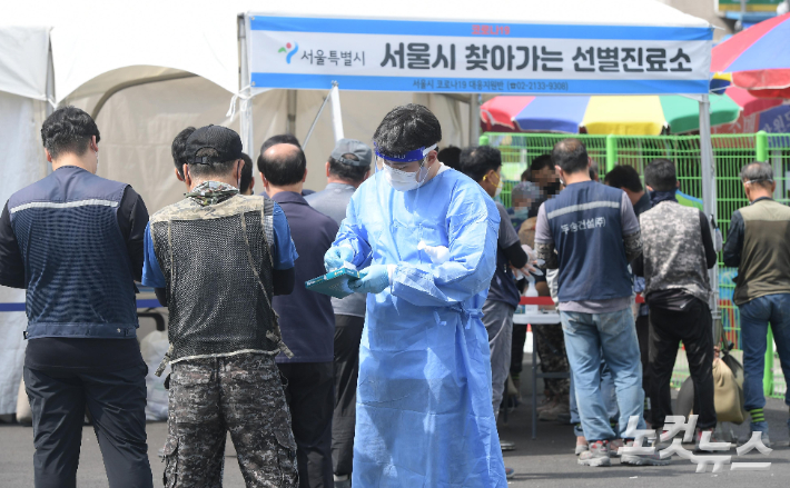  서울 동대문구 청량리수산시장 주차장에 설치된 선별진료소에서 시민들이 코로나19 검사를 받기 위해 줄 서 있다. 이한형 기자