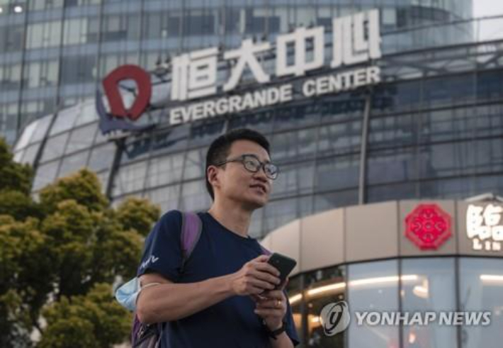 지난 21일 한 남성이 중국 상하이의 헝다센터 앞을 지나는 모습. 연합뉴스