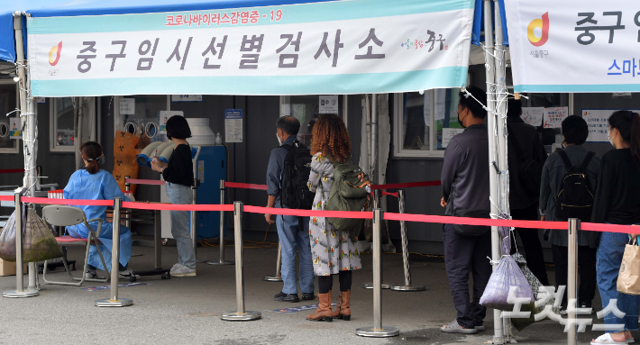 코로나19 신규 확진자 수가 3273명을 기록하며 처음으로 3000명을 넘어선 25일 서울역 임시선별검사소를 찾은 시민들이 검사를 받기 위해 줄을 서 있다. 박종민 기자