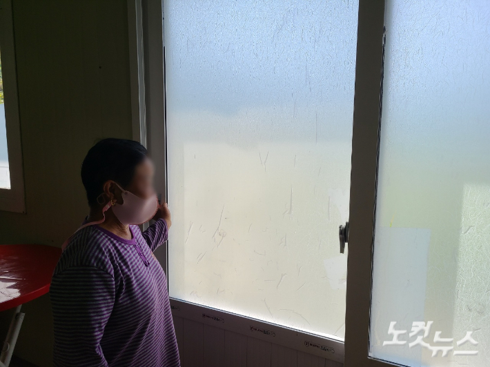 한 주민이 한여름에도 열 수 없는 문을 가리키며 어려움을 호소하고 있다. 김정남 기자