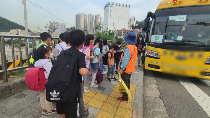 등교시간 스쿨버스에서 하차하는 구평초 학생들. 학교에 별도 하차장이 없어 인근 버스 정류장에서 하차해 걸어 올라간다. 구평초학부모회 제공