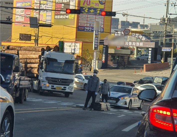 구평초 스쿨버스가 다니는 구간인 구평고개 삼거리에 화물차 적재물이 떨어져 경찰이 통제 중인 모습. 구평초학부모회 제공