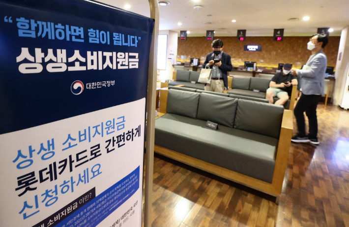 용·체크카드를 예전보다 많이 쓰면 늘어난 사용액 일부를 돌려주는 상생소비지원금(카드 캐시백) 제도 신청이 시작된 지난 1일 서울 시내 한 카드사 고객센터에 상생소비지원금 관련 안내문이 설치되어 있다. 연합뉴스