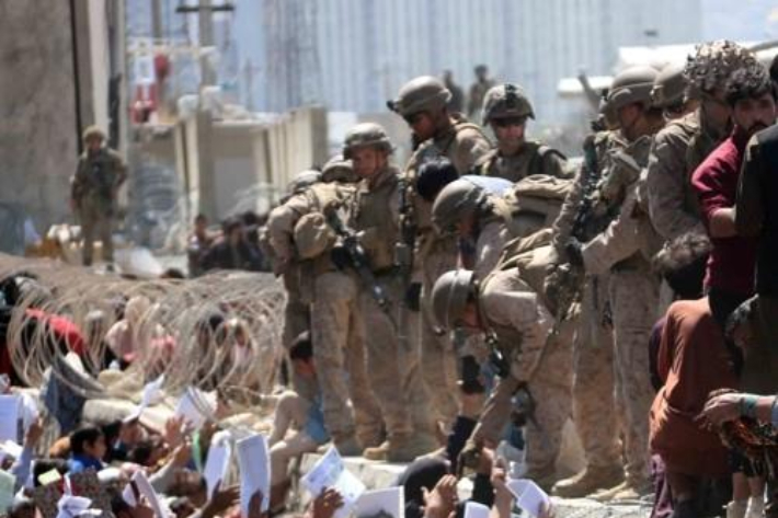 이슬람 무장조직 탈레반이 장악한 아프가니스탄을 탈출하려는 피란민들이 지난 8월 26일(현지시간) 수도 카불의 하미드 카르자이 국제공항을 경비하는 미군 등 외국군을 향해 자신들의 신원증명서를 흔들며 탈출 지원을 호소하고 있다. 연합뉴스