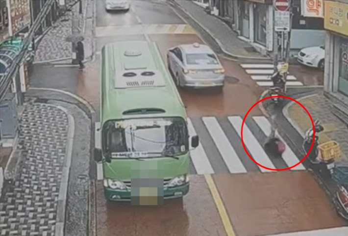 지난 1월 부산 해운대구 한 도로에서 A씨(빨간 원)가 고의로 택시에 부딪혀 넘어지는 모습. 부산경찰청 제공