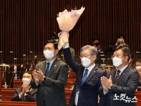 민주당 의총, 꽃다발 들어보이는 이재명 대선후보