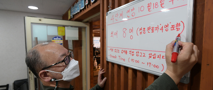  15일 서울 종로구 한 식당에서 식당 주인이 거리두기 관련 내용을 적고 있다. 이한형 기자
