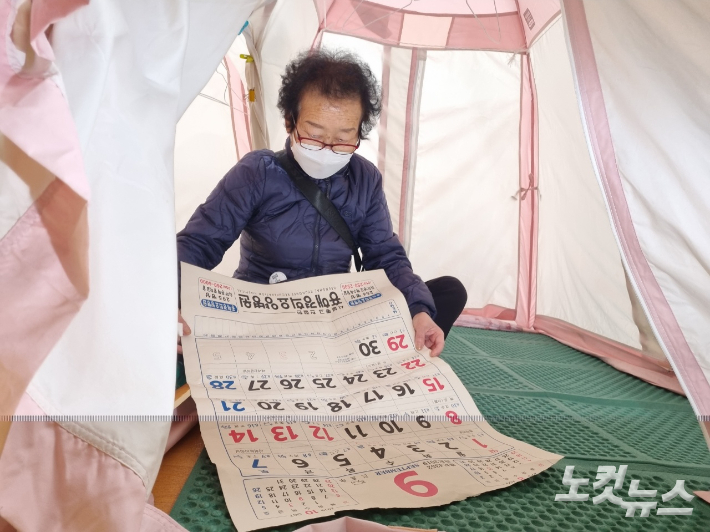 포항지진 이재민 이순오씨가 구호소내 텐트에서 난방효과를 위해 이용한 달력을 보고 있다. 김대기 기자