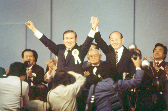 1987년 민정당 전당대회에서 대통령 후보로 지명된 노태우 대표(왼쪽)가 전두환 대통령과 손을 맞잡고 대의원들의 환호에 답하는 모습. 연합뉴스