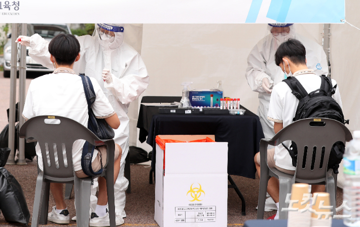 지난달 28일 서울 종로구 동성고등학교에서 학생들이 등교하며 코로나19 '신속 자가분자진단 유전자증폭(신속 PCR)' 검사를 받는 모습. 사진공동취재단