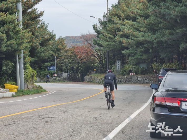 한 자전거 운전자가 하오고개 도로 한가운데로 내리막길을 달리고 있다. 정성욱 기자
