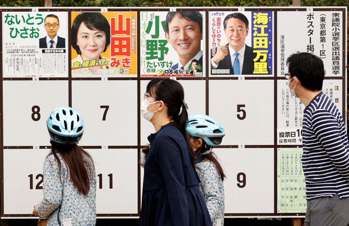 일본 중의원(하원) 선거 투표일인 지난달 31일 수도 도쿄의 투표소 밖에서 한 유권자가 선거 벽보를 살펴보는 모습. 연합뉴스