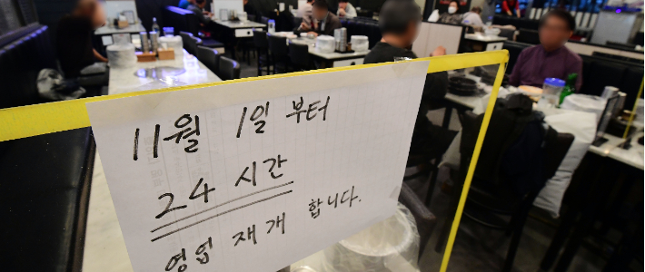 '단계적 일상회복' 1차 개편 시행을 하루 앞둔 31일 오후 서울 마포구 한 식당에 24시간 영업재개 안내문이 부착돼 있다. 1일부터 적용하는 첫 단계에서는 유흥시설 등을 제외한 모든 생업시설의 영업시간 제한이 전면 해제된다. 황진환 기자