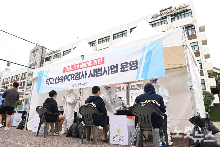 지난달 28일 서울 종로구 동성고등학교에서 학생들이 등교하며 코로나19 '신속 자가분자진단 유전자증폭(신속 PCR)' 검사를 받는 모습. 사진공동취재단