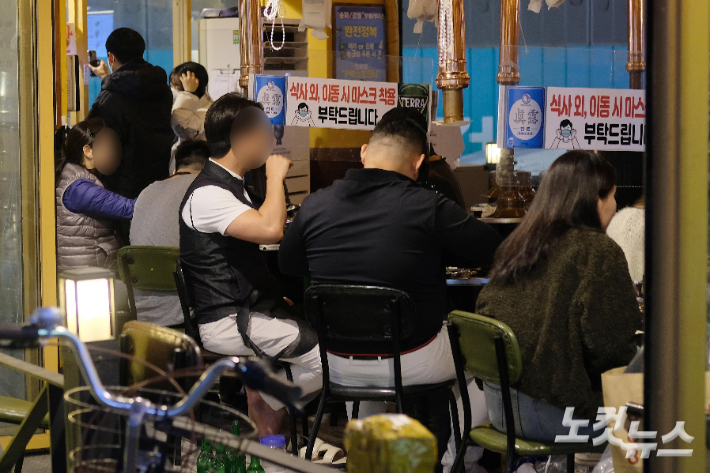 '단계적 일상회복'(위드 코로나) 1단계 시행 첫날인 1일 서울 송파구 신천 먹자골목에서 시민들이 담소를 나누며 음식을 먹고 있다. 일상회복이 시작되면서 수도권은 10명까지, 비수도권은 12명까지 모일 수 있고, 식당·카페 등 대부분 시설은 24시간 영업이 가능해진다. 박종민 기자