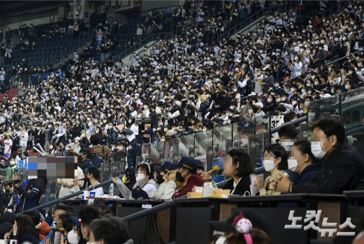 지난 1일 오후 서울 송파구 잠실구장에서 열린 프로야구 2021 신한은행 쏠(SOL) KBO 포스트시즌 와일드카드 결정전 키움 히어로즈와 두산 베어스의 경기. 관중들이 음식을 먹고 있다. 정부는 이날부터 단계적 일상회복 지침을 시행하면서 한국야구위원회(KBO)는 포스트시즌 전 경기 좌석을 100% 백신 접종자 구역으로 운영하기로 결정했다. 관중은 입장 시 백신접종 완료 증명서나 48시간 이내에 발급된 PCR 음성확인서를 제시해야 한다. 불가피하게 접종을 하지 못한 팬은 의사의 소견서를 지참하면 입장이 가능하다. 이한형 기자