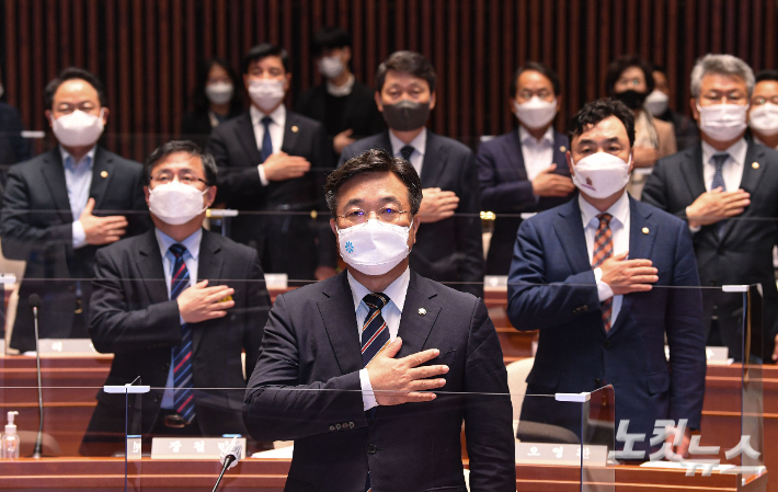 윤호중 더불어민주당 원내대표를 비롯한 의원들이 4일 국회에서 열린 정책의원총회에서 국민의례를 하고 있다. 윤창원 기자