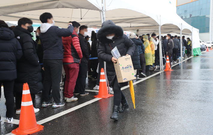 전북 익산시 시민들이 10일 체육관 앞에 요소수를 사기 위해 줄지어 서 있는 가운데 한 시민이 요소수를 사서 나오고 있다. 연합뉴스