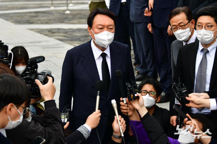 윤석열 국민의힘 대선후보가 11일 오후 경남 김해시 봉하마을을 찾아 고 노무현 전 대통령 묘역에 참배를 하고 취재진의 질문을 받고 있다.