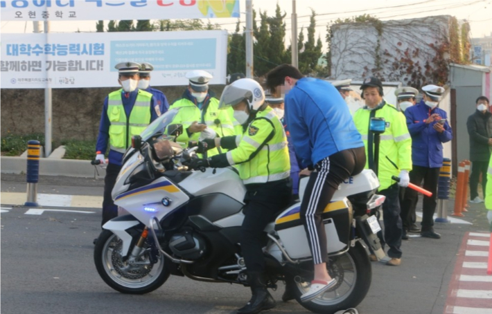 대학수학능력시험(수능)일인 18일 제주도교육청 제주95지구 제3시험장인 오현고등학교 정문 앞에서 한 수험생이 경찰 오토바이를 타고 온 후 내리고 있다. 연합뉴스