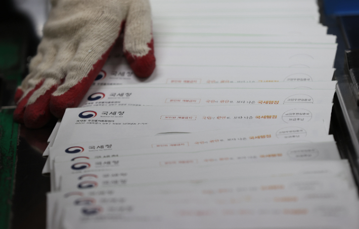 지난 23일 오후 서울 강남우체국에서 관계자들이 종합부동산세 고지서를 집배순로구분기를 통해 분류하기 위해 준비하는 모습. 연합뉴스