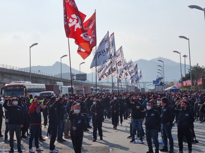 25일 부산신항 삼거리에서 열린 화물연대 총파업 출정식에서 노조원들이 깃발을 들고 입장하고 있다. 박진홍 기자