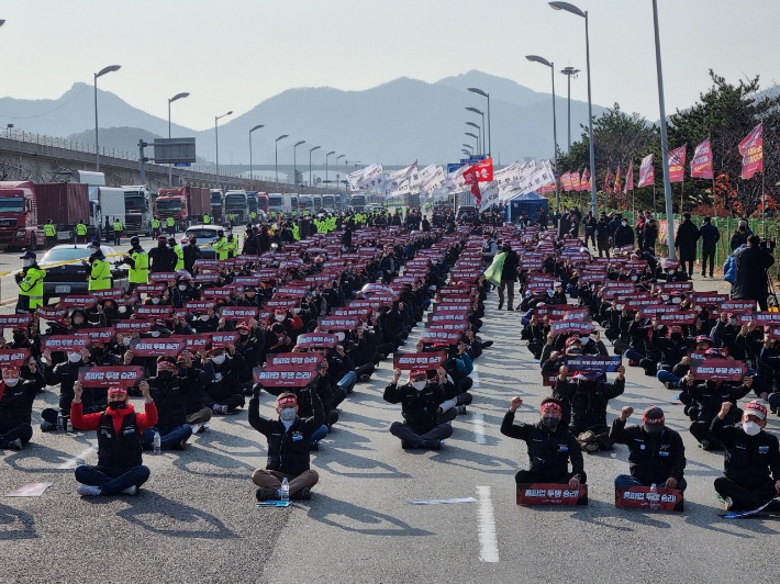 25일 부산신항 삼거리에서 열린 화물연대 총파업 출정식에서 참가자들이 피켓을 들고 있다. 박진홍 기자