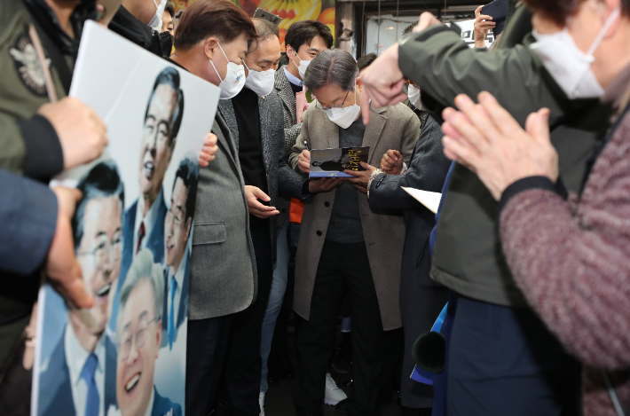 더불어민주당 이재명 대선후보가 26일 오전 전남 목포시 동부시장을 방문, 지지자들에게 사인해주고 있다. 연합뉴스