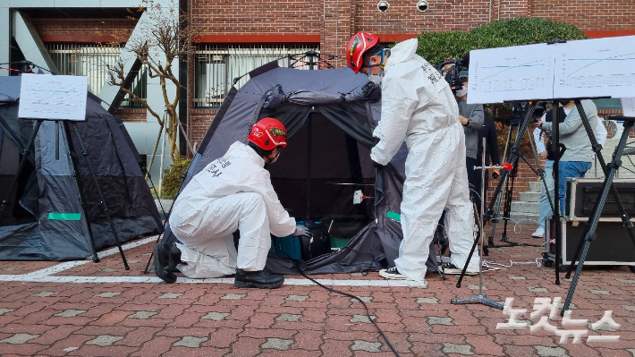 7일 부산 부경대에서 열린 캠핑용 난방기구 일산화탄소 중독 실험 현장에서 소방대원들이 텐트 안에 무시동히터를 설치하고 있다. 박진홍 기자