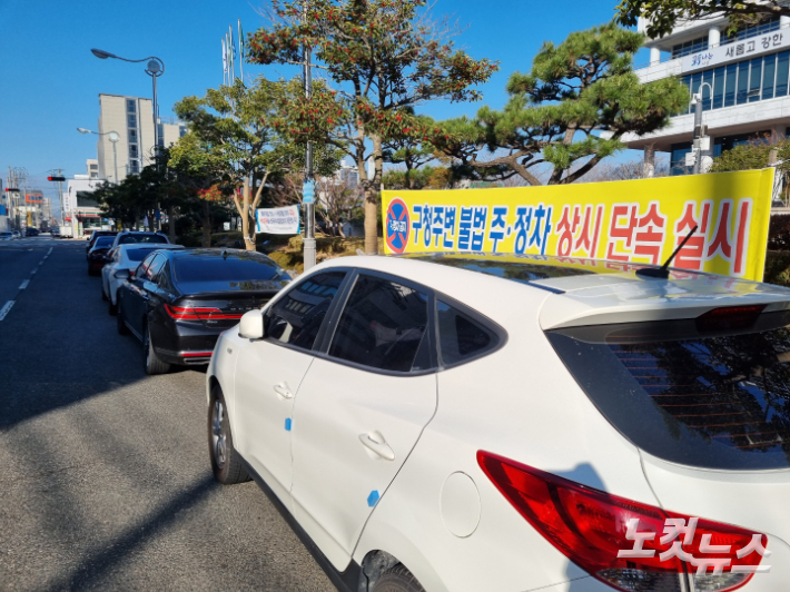 10일 사상구청 앞 도로에 불법 주차된 차량들 옆으로 '불법 주정차 단속 실시' 현수막이 걸려 있다. 박진홍 기자