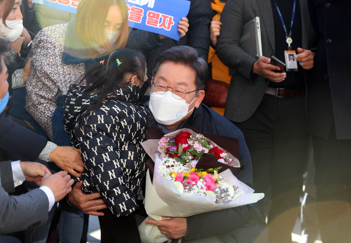 더불어민주당 이재명 대선 후보가 13일 경북 포항시 북구 죽도시장을 찾은 자리에서 어린이에게 꽃다발을 받고 있다. 연합뉴스