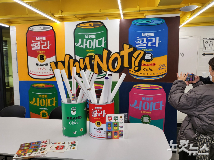 14일 서울 중구 무교동 노브랜드 버거 서울시청점에서 방문객이 브랜드 콜라, 사이다를 팝아트로 그려낸 그래피티 월을 찍고 있다. 조혜령 기자 