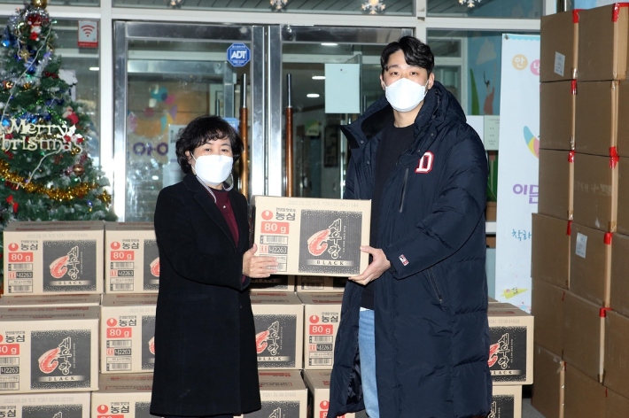 두산 베어스 양석환(오른쪽)이 14일 서울 성동구 보육시설 이든아이빌을 찾아 과자 박스를 전달하고 있다. 두산