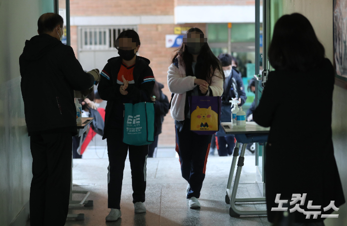 전국 초·중·고교 전면등교가 실시된 지난달 22일 서울 강서구 염창중학교에서 학생들이 등교를 하며 손소독을 하고 있다. 사진공동취재단