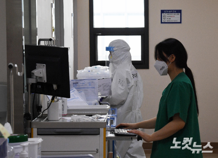 지난 17일 경기 성남시 국군수도병원에서 완전방역복을 입은 의료진이 감염병동에서 분주히 움직이고 있다. 박종민 기자