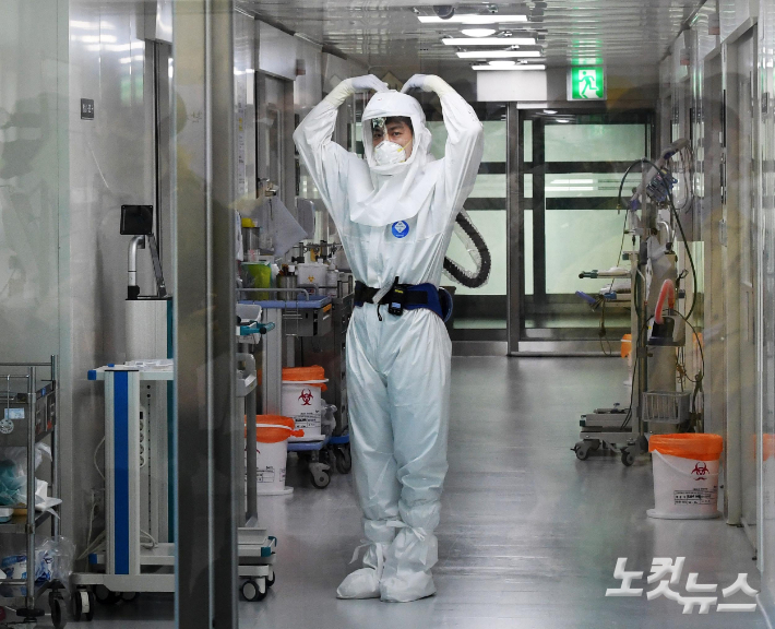 지난 17일 경기 성남시 국군수도병원에서 완전방역복을 입은 의료진이 감염병동에서 업무 중 하트 모양을 만들어 보이고 있다. 박종민 기자