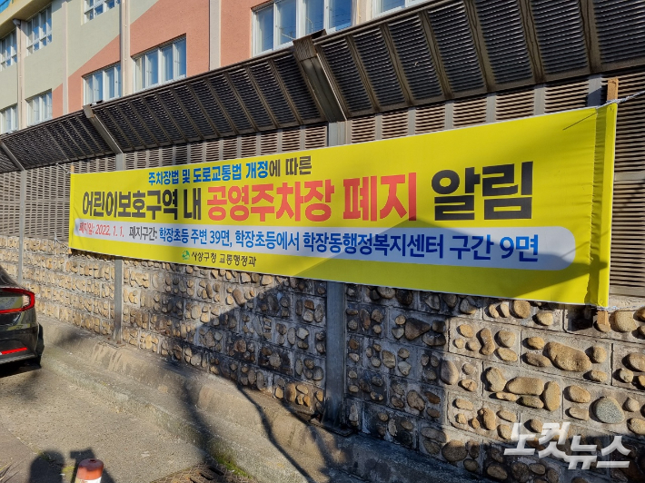 부산 사상구 한 초등학교 인근 노상주차장에 주차장 폐지 알림 공고가 붙은 모습. 박진홍 기자