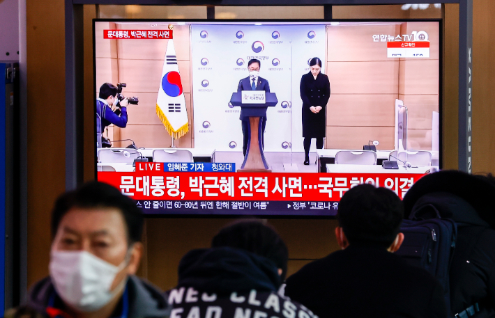 24일 오전 서울역에서 시민들이 박범계 법무부 장관의 사면 관련 발표 방송을 보고 있다. 연합뉴스