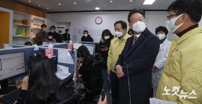 이재명 더불어민주당 대선 후보가 25일 서울 강남구 보건소 재택치료 모니터링 센터를 방문하여 관계자의 설명에 귀를 기울이고 있다.