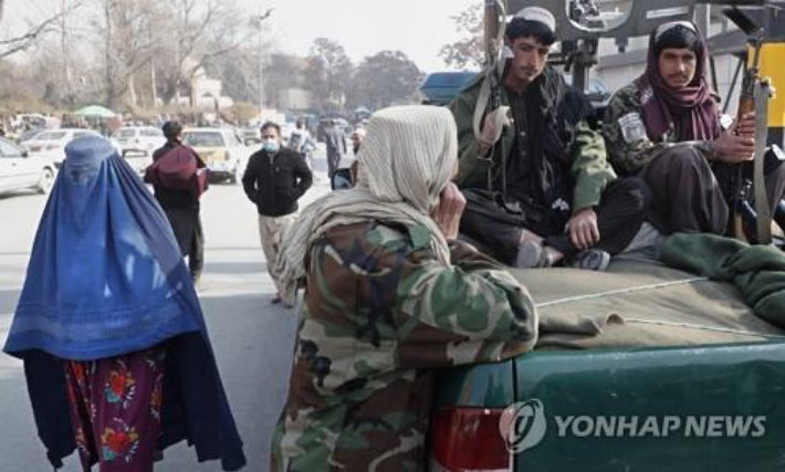 부르카를 쓰고 탈레반 대원 옆을 지나는 아프간 여성(왼쪽). 연합뉴스