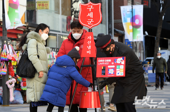 구세군 모금활동이 본격적으로 시작된 1일 오후 서울 명동거리에서 한 가족이 구세군 냄비에 성금을 기부하고 있다. 황진환 기자