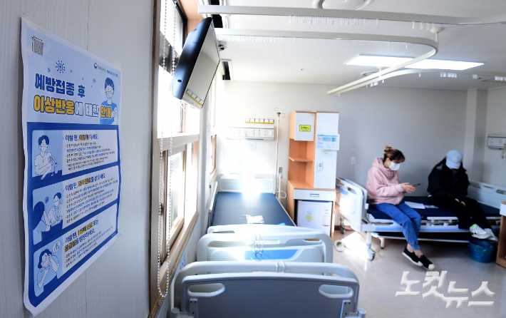 서울 양천구 홍익병원에서 한 학생이 코로나19 백신접종을 마친 뒤 이상반응 관찰을 위해 어머니와 대기하고 있다. 사진공동취재단