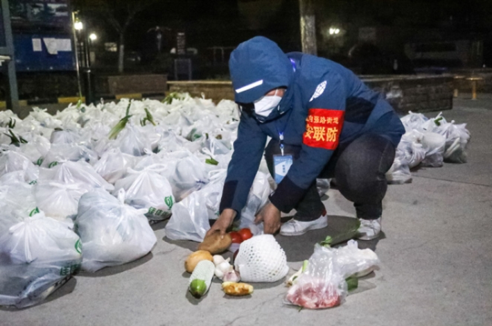 중국 북서부 산시성 시안시에 있는 한 자원봉사자가 12일 밤 채소와 다른 음식을 주민들에게 전달할 준비를 하고 있다. 차이신 캡처