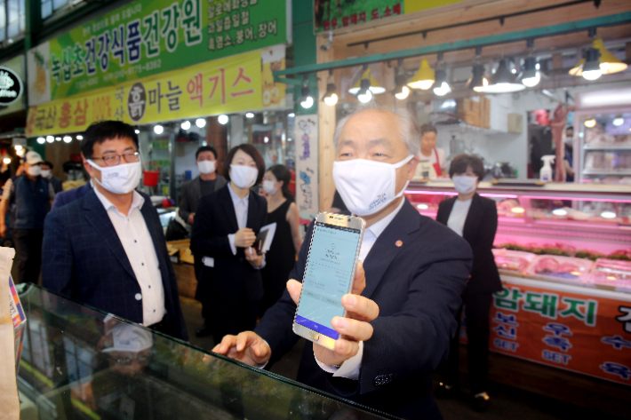 조봉환 이사장이 대전 도마큰시장 행사장에서 모바일 온누리상품권으로 결제하고 있는 모습. 소상공인시장진흥공단 제공