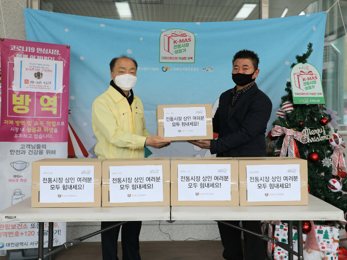 조봉환 이사장(왼쪽)이 대전 도마큰시장에서 방역물품을 전달하고 있는 모습. 소상공인시장진흥공단 제공